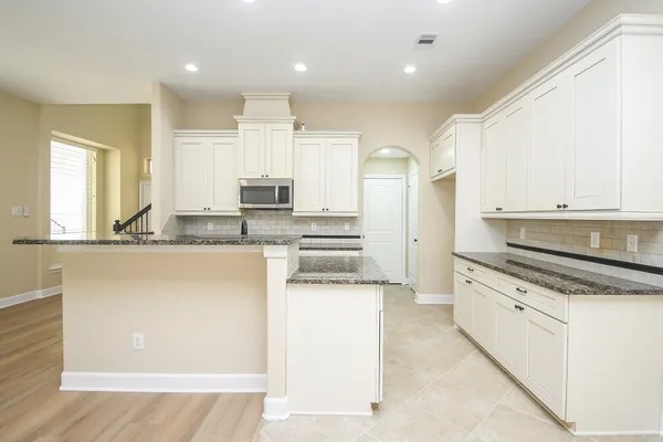 a kitchen with granite countertop a sink stove and cabinets
