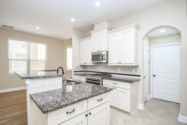 a kitchen with granite countertop a sink and a stove