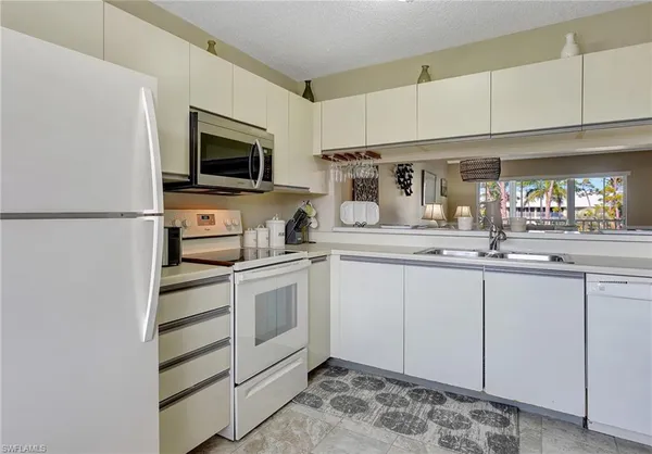 a kitchen with granite countertop a sink and stainless steel appliances
