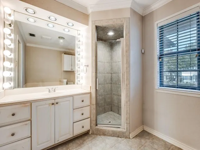 a spacious bathroom with a shower sink and mirror