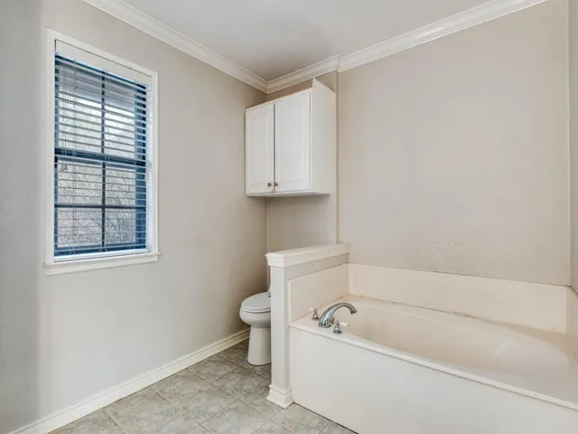 a bathroom with a toilet bathtub and window