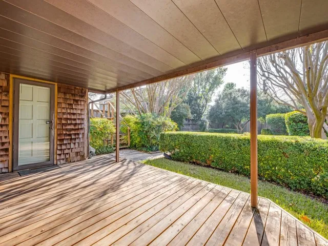 a view of a porch with wooden floor and fence