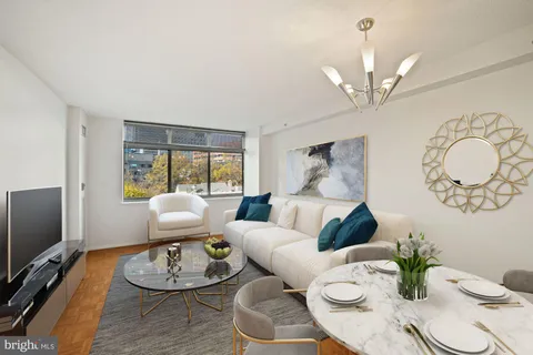 a living room with furniture chandelier and a flat screen tv