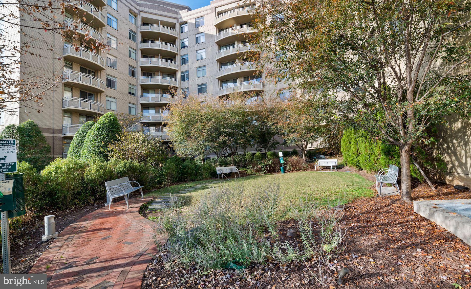 7111 Woodmont Avenue, Unit 514 Chevy Chase, MD 20815 - Photo 2 of 38 a backyard of a building with large trees