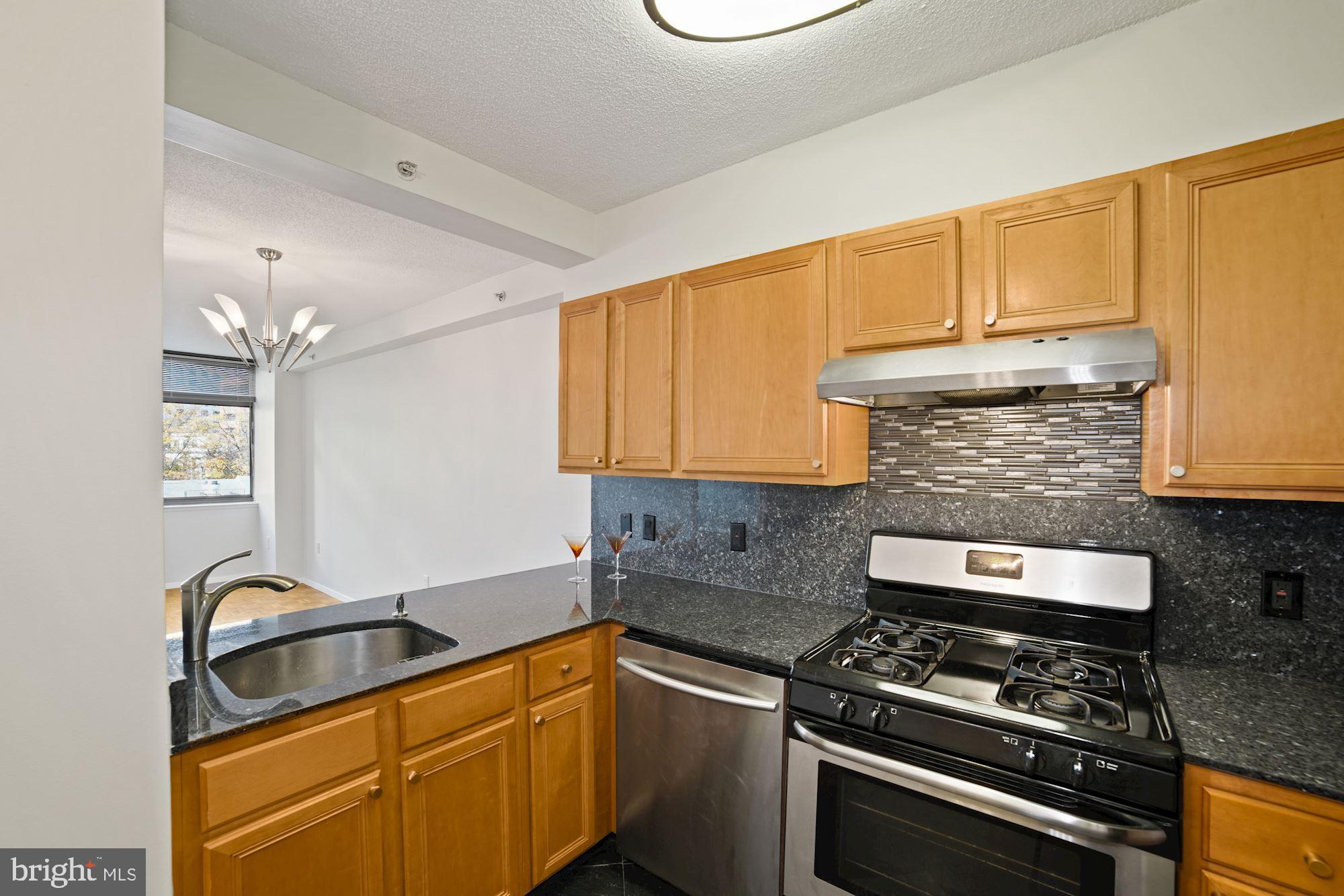 7111 Woodmont Avenue, Unit 514 Chevy Chase, MD 20815 - Photo 8 of 38 a kitchen with stainless steel appliances a sink stove and cabinets