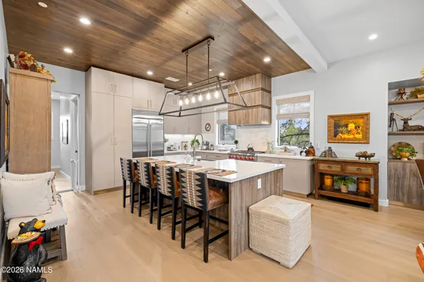 a kitchen with kitchen island a stove a table and chairs in it