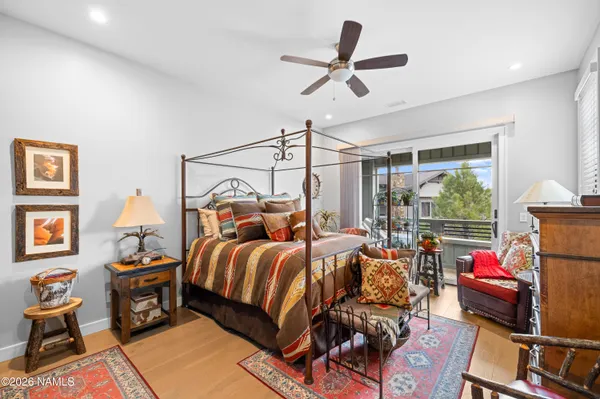 a bedroom with a bed a flat screen tv and a chandelier