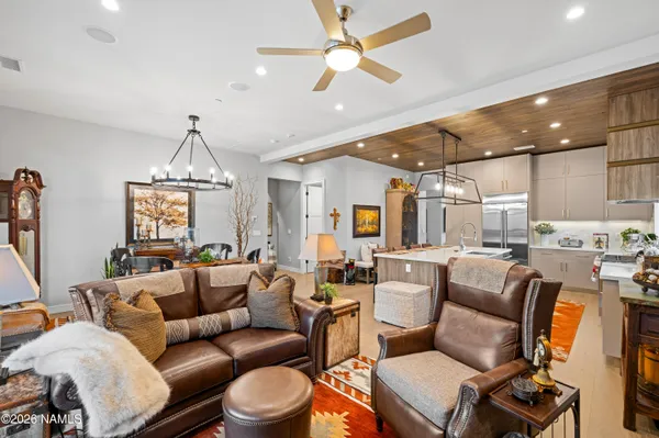 a living room with furniture a ceiling fan and a chandelier