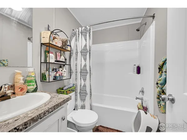 a bathroom with a granite countertop sink a toilet and shower