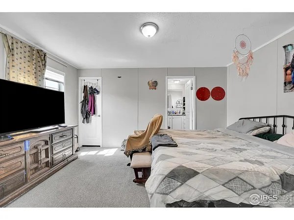 a bedroom with a bed and flat screen tv