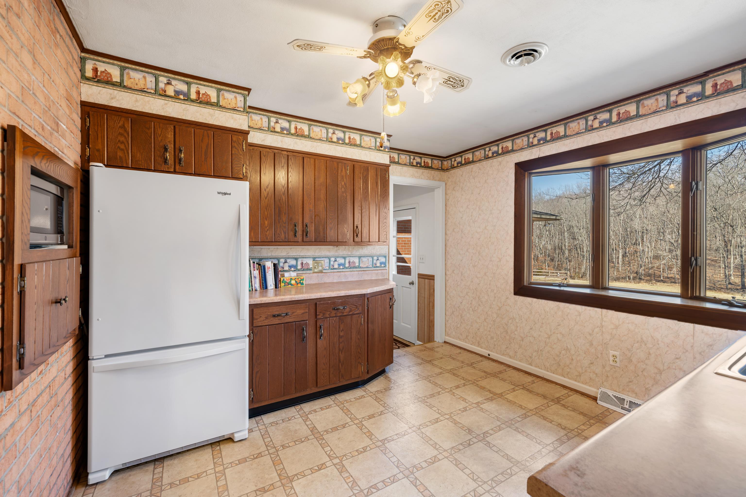 431 Mt Pisgah Road Mount Sidney, VA 24467 - Photo 24 of 72 a kitchen with stainless steel appliances granite countertop a refrigerator a sink dishwasher a stove with white cabinets and wooden floor