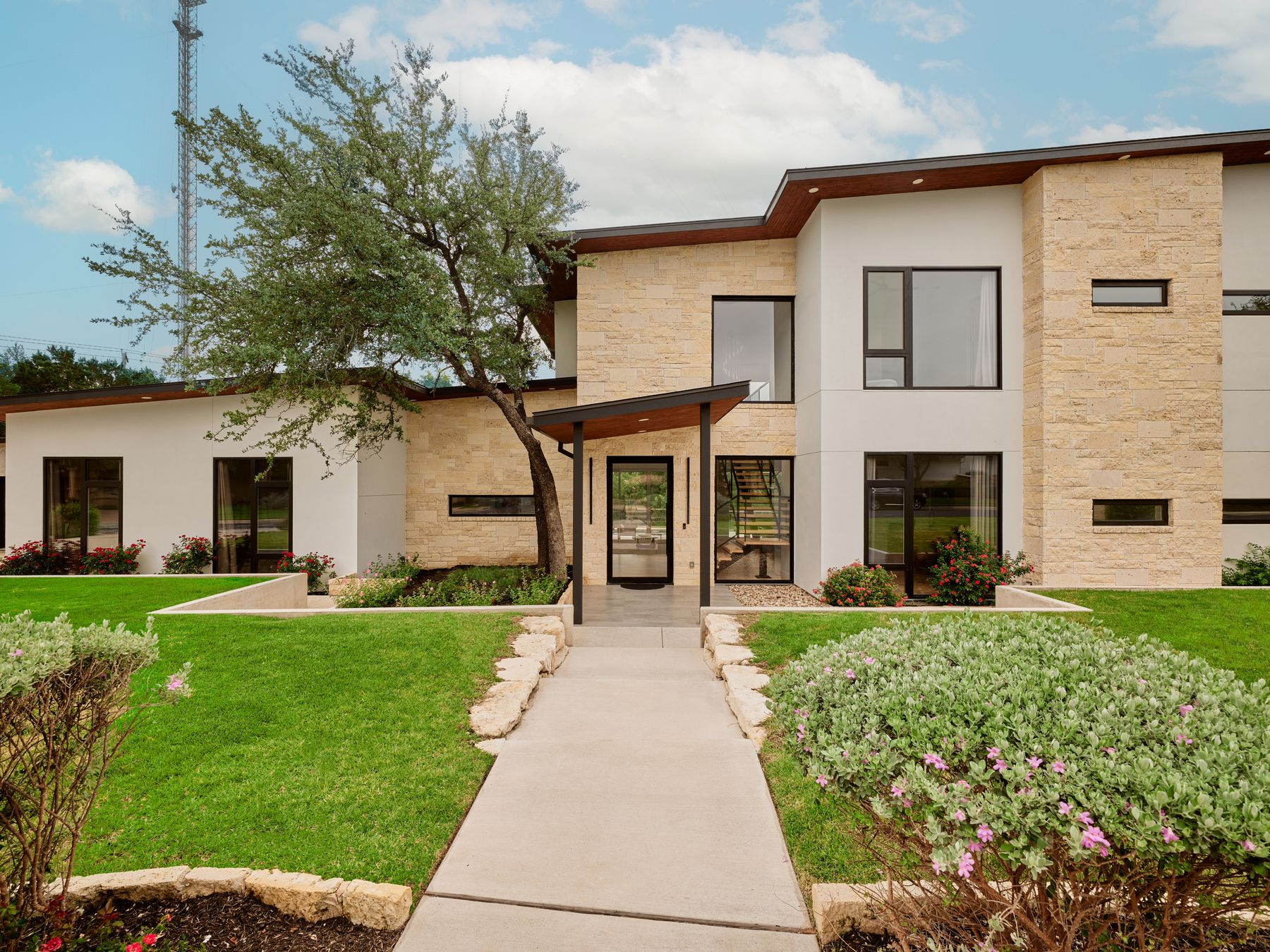 2476 Waymaker Way Austin, TX 78746 - Photo 29 of 31 Clean lines and natural stone accents define this inviting contemporary facade with ample lawn space.