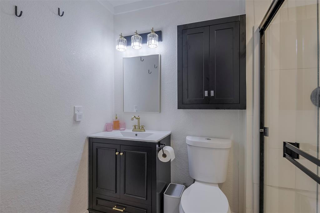 472 Cox Road Waxahachie, TX 75167 - Photo 12 of 31 Bathroom featuring a dark wood-finish vanity with a white countertop, a wall-mounted mirror, and a three-light fixture