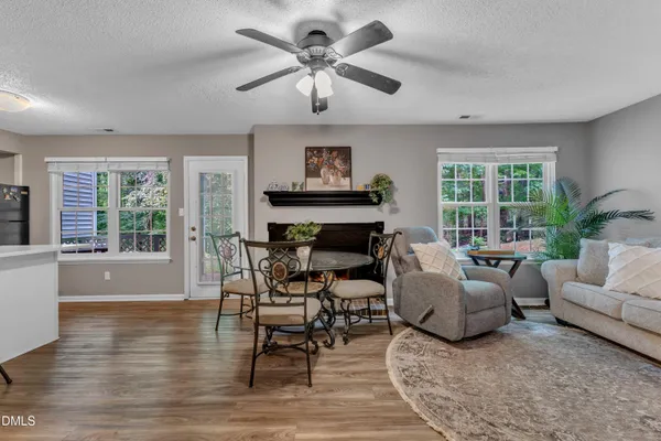 a living room with furniture a fireplace and a large window