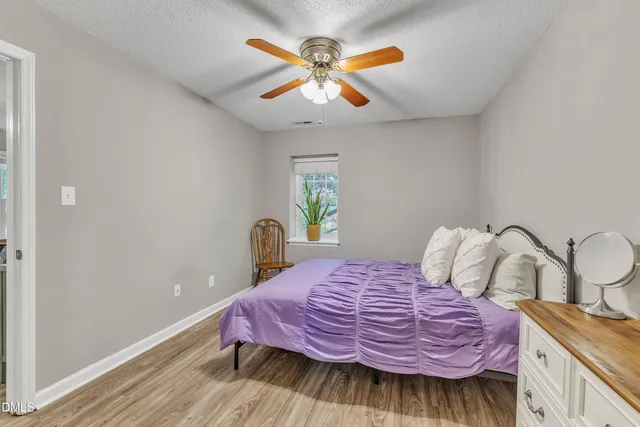 a bedroom with a bed and a potted plant
