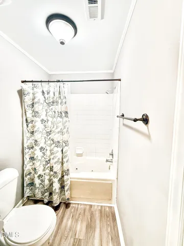 a bathroom with a toilet and a shower curtain