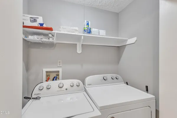 a utility room with dryer washer and empty racks