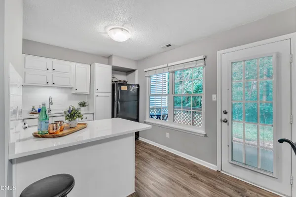 a kitchen with a refrigerator a stove a sink and a window with wooden floor