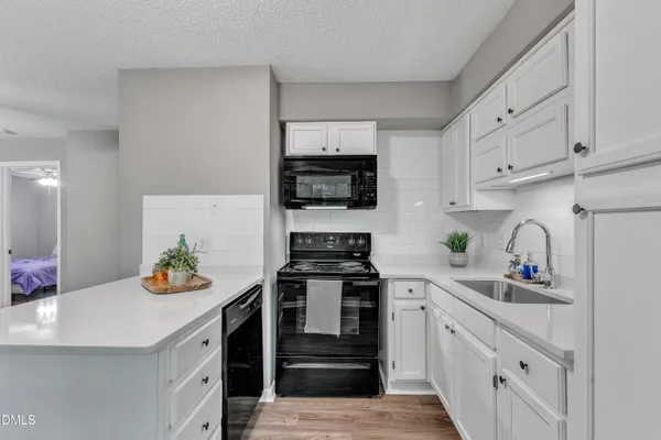 a kitchen with white cabinets and appliances
