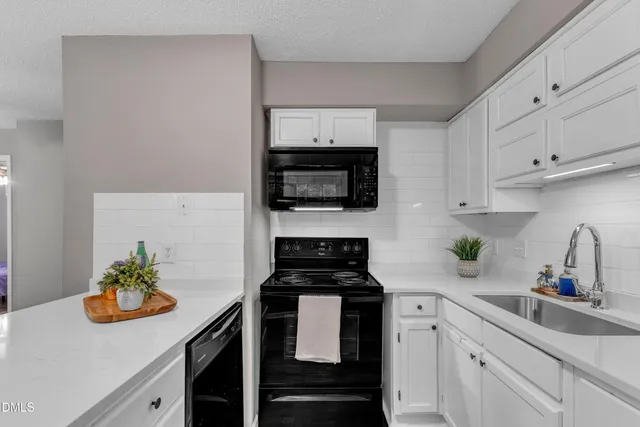 a kitchen with a sink a stove and cabinets
