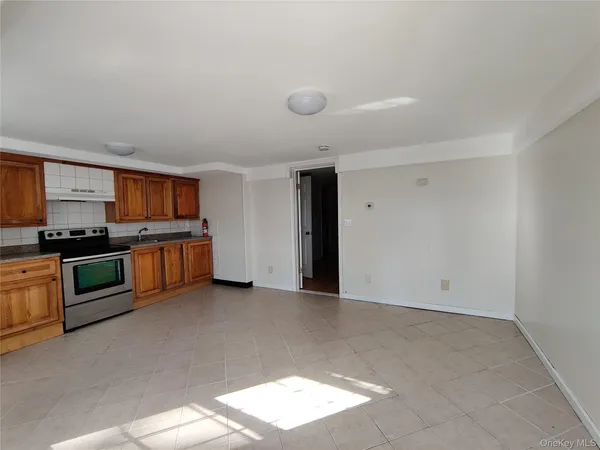 a view of kitchen with stainless steel appliances granite countertop a stove and a refrigerator