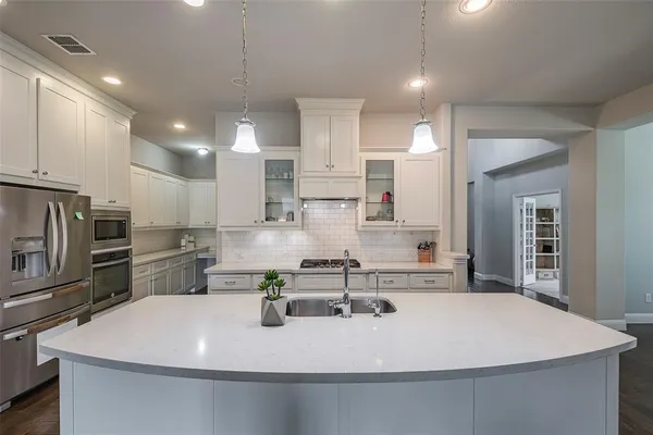 a kitchen with kitchen island a sink and appliances