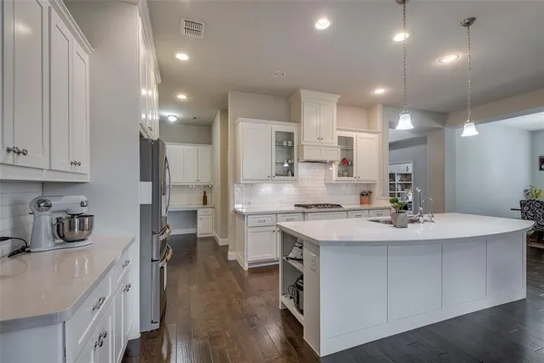 a kitchen with kitchen island a sink stove and refrigerator