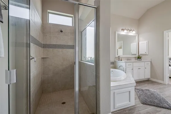 a bathroom with a double vanity sink a mirror and a shower
