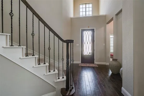 a view of a hallway with wooden floor and staircase