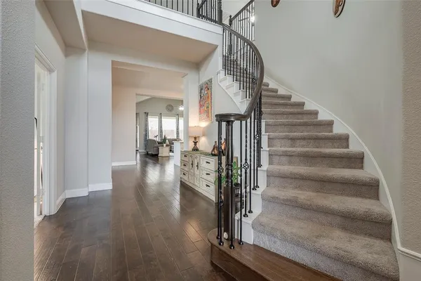 a view of entryway and hall with wooden floor