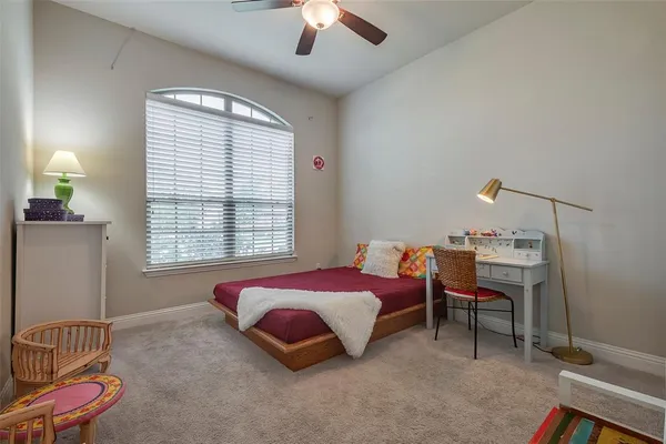 a spacious bedroom with a bed and a chandelier