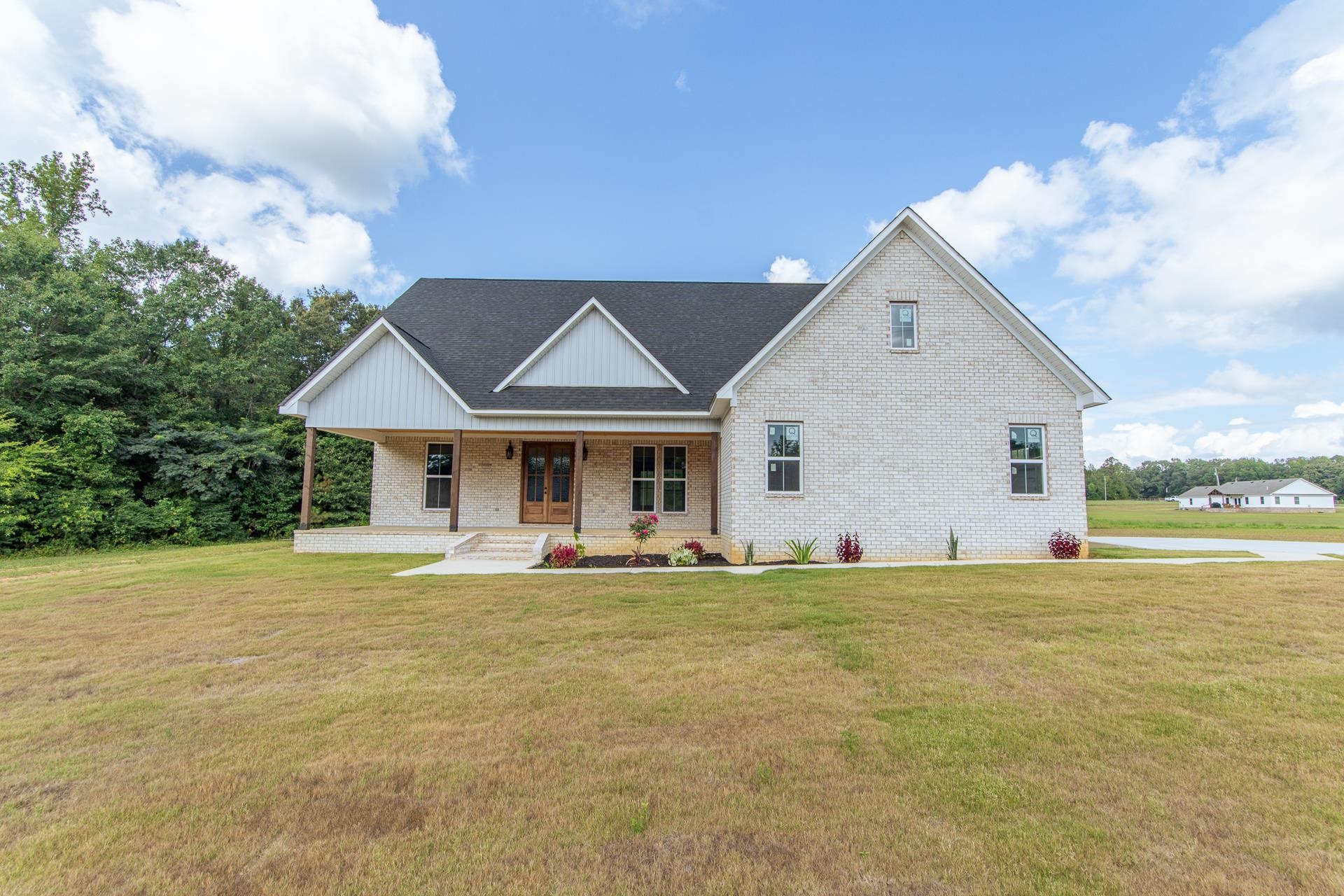 a front view of a house with a garden and yard