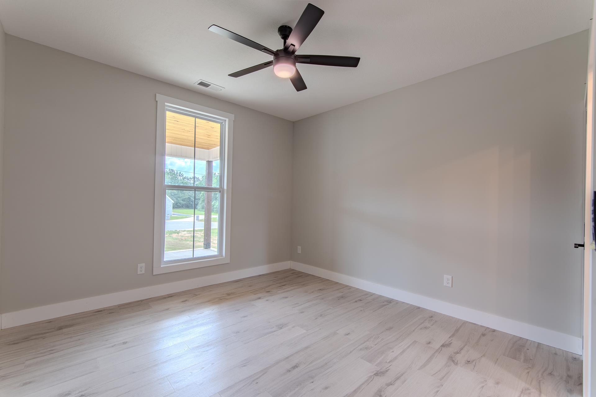 90 Columbus Lane Adamsville, TN 38310 - Photo 21 of 40 an empty room with wooden floor and windows