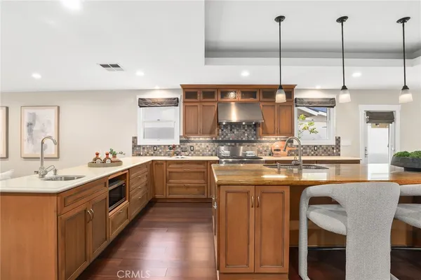 a kitchen with stainless steel appliances granite countertop a sink a stove and a wooden floors