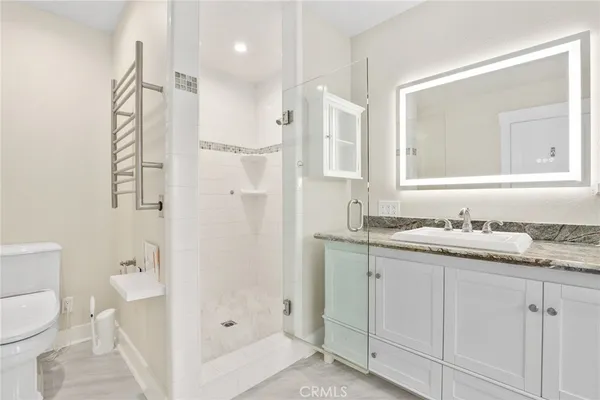 a bathroom with a granite countertop sink toilet a shower and a mirror