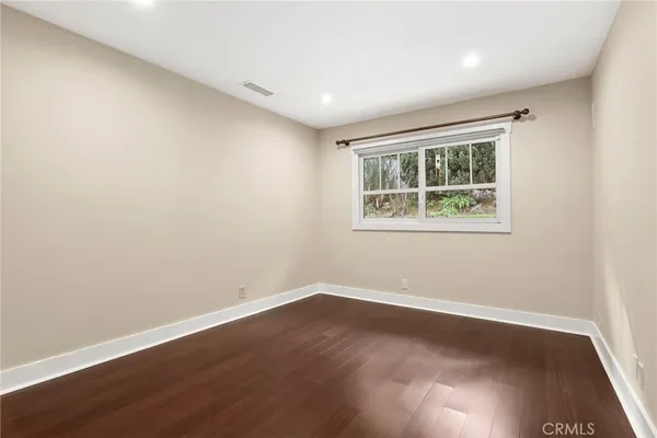 a big room with wooden floor and windows
