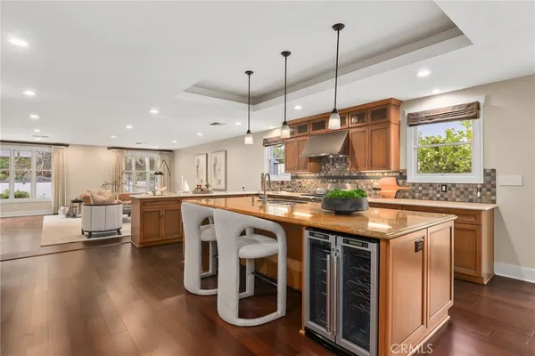 a kitchen with kitchen island granite countertop a stove and a wooden floor