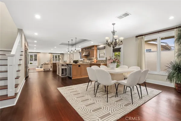 a dining room with furniture a chandelier and wooden floor