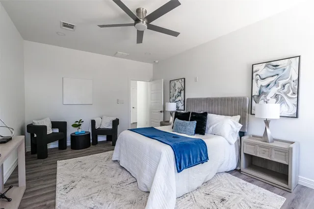 an empty room with wooden floor exposed radiator and windows