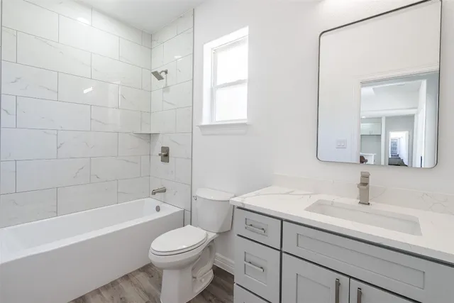 a view of a hallway with wooden floor and a window
