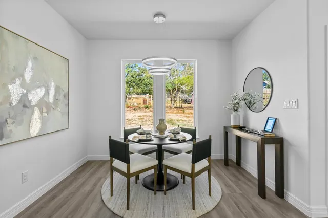 a dining room with furniture a chandelier and wooden floor