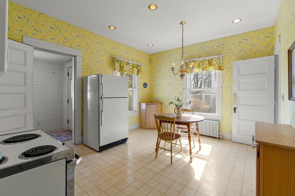 118 Sanders Avenue Lowell, MA 01851 - Photo 15 of 42 a kitchen with stainless steel appliances granite countertop a refrigerator a oven a sink a dining table and chairs with wooden floor