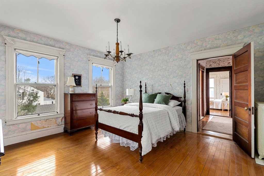 118 Sanders Avenue Lowell, MA 01851 - Photo 28 of 42 a bedroom with a bed and a chandelier