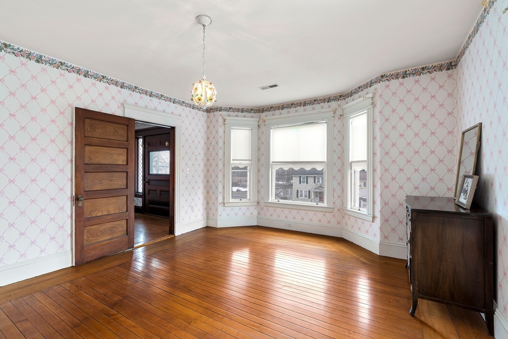 118 Sanders Avenue Lowell, MA 01851 - Photo 29 of 42 a view of an empty room with a window and wooden floor
