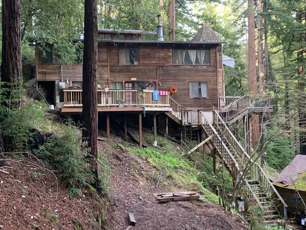 a front view of house with yard and trees around