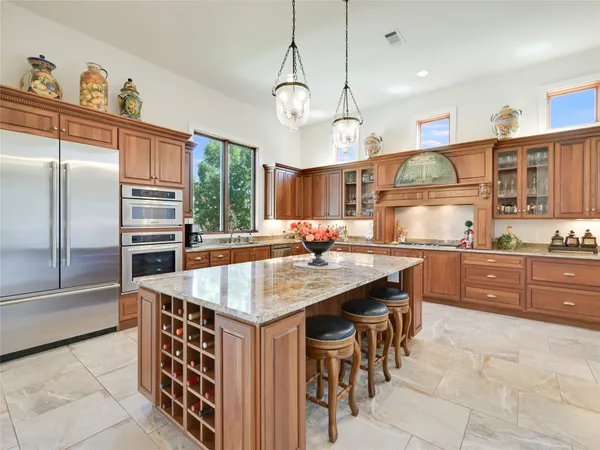 a kitchen with stainless steel appliances granite countertop a sink a stove and a refrigerator