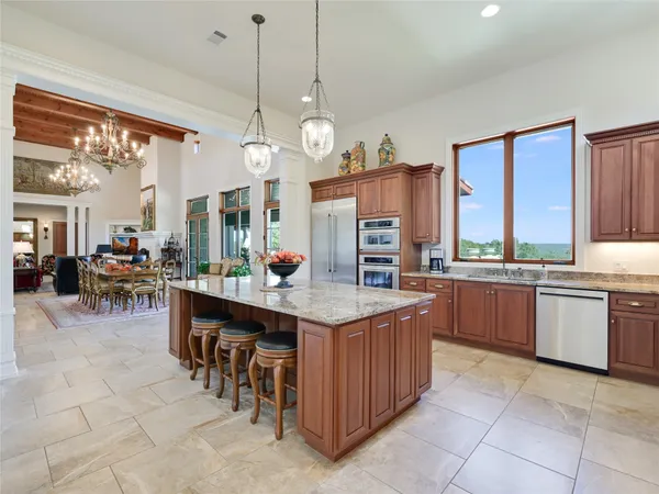 a open kitchen with stainless steel appliances granite countertop a stove oven a kitchen island a sink and cabinets