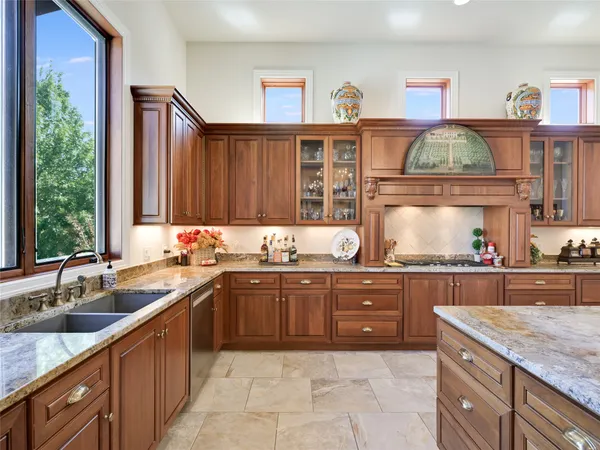 a kitchen with stainless steel appliances granite countertop a sink and wooden cabinets