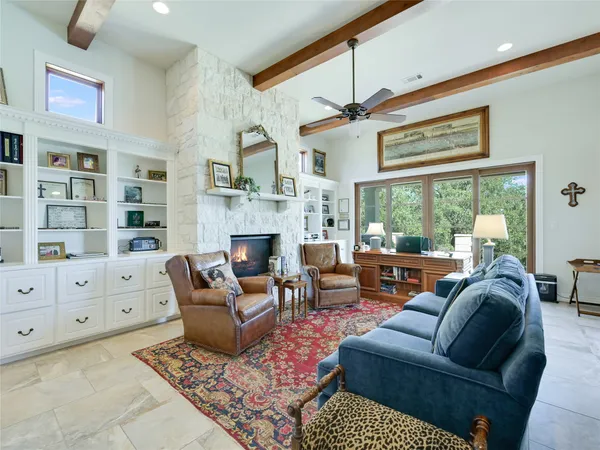 a living room with furniture fireplace and a large window