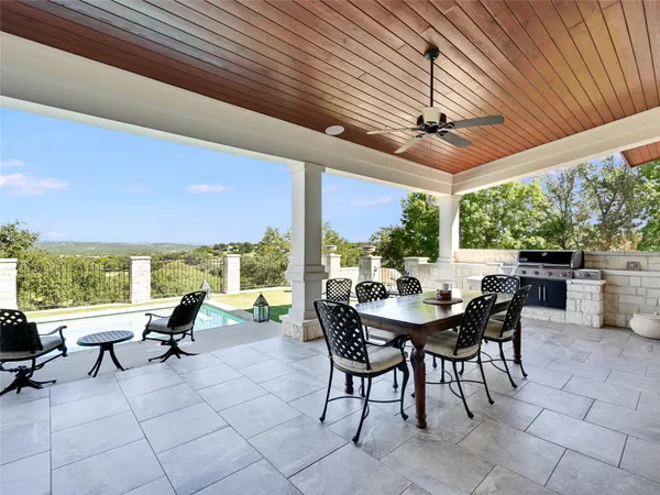 a view of a patio with table and chairs and floor to ceiling window